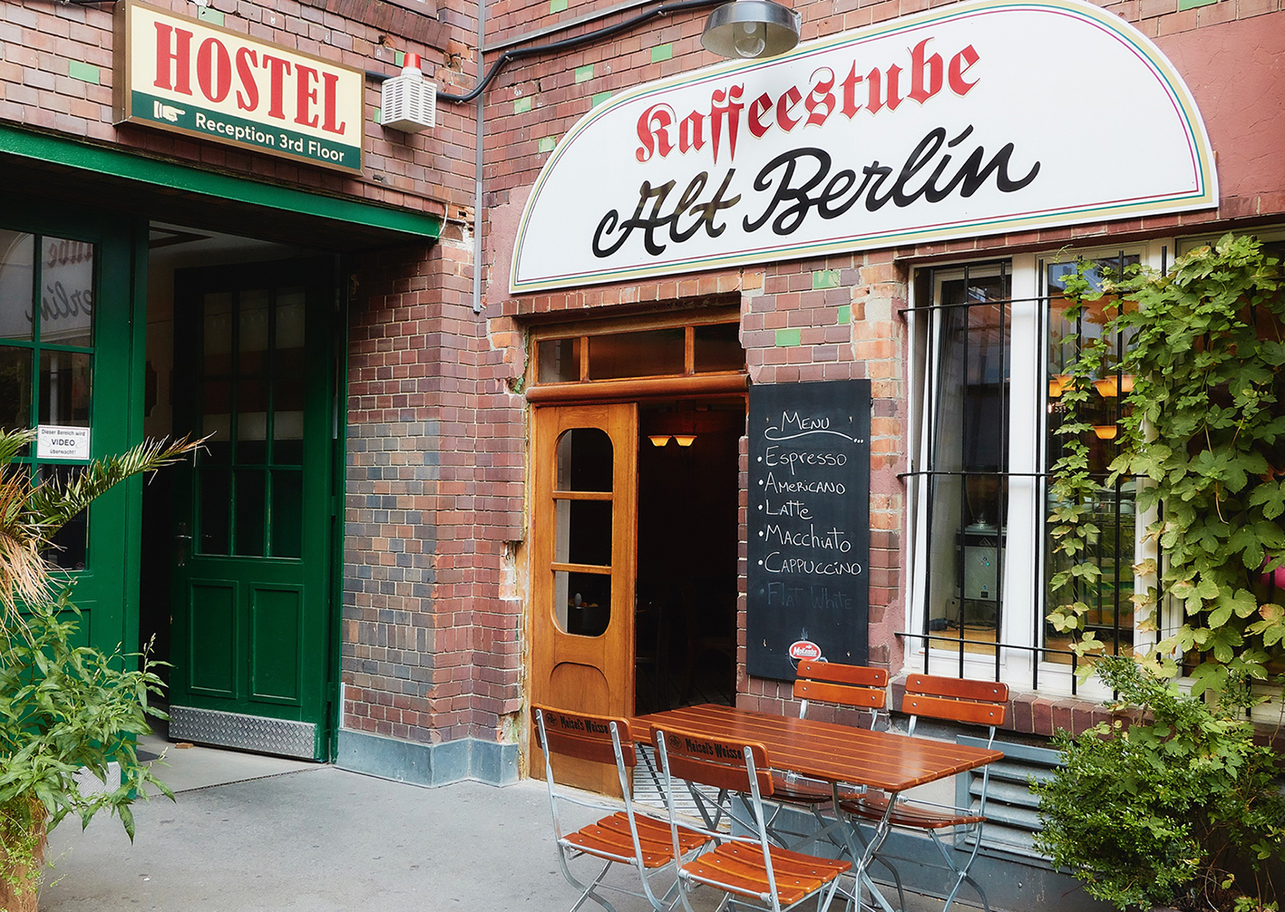 Eingang der Kaffeestube Alt Berlin mit handgemaltem Schild, Menütafel und Klappstühlen vor der Backsteinfassade